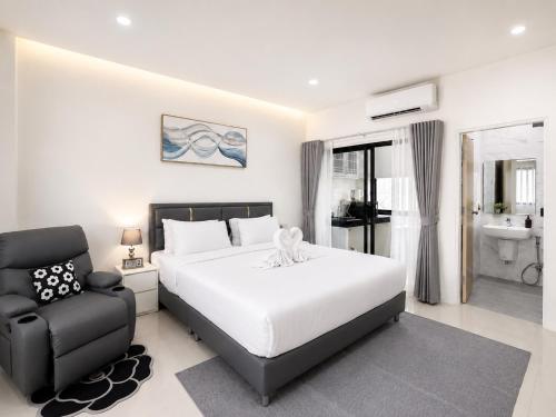a bedroom with a white bed and a chair at Tonjun residence samui in Chaweng