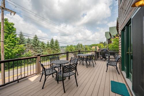 a deck with tables and chairs on a balcony at Cedar Shores Villa #08 by Railey Vacations in McHenry