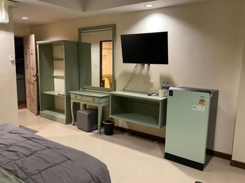 a bedroom with a bed and a tv on the wall at Tuek Khiaw Samui Hotel in Bophut