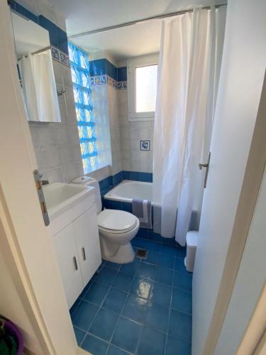 a bathroom with a toilet and a tub and a sink at Villa Elena in Ormos Panagias