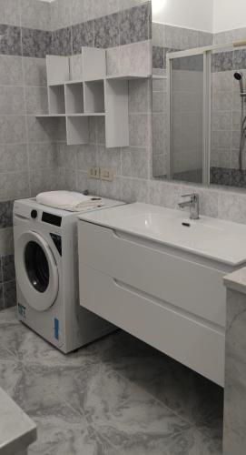 a bathroom with a washing machine and a sink at Magnolia Rooms - Val Di Chy in Val di Chy