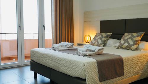 a bedroom with a large bed with towels on it at Mini B&B - Alessandro Volta in Rende