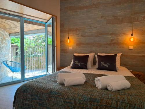 a bedroom with a large bed with two pillows on it at Casa Tritão - Gerês in Campo do Gerês