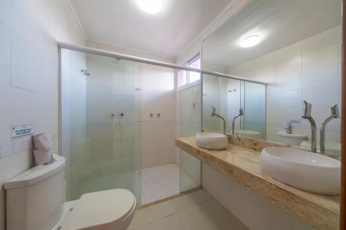 a bathroom with a toilet and a sink and a shower at Areias de Itacimirim in Itacimirim