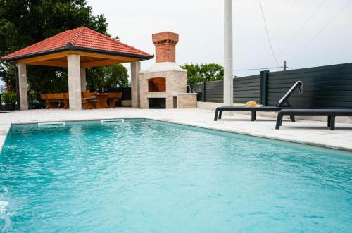 a swimming pool in a yard with a gazebo at Villa Dub in Stolac