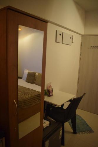 a small room with a bed and a desk and a mirror at Zen LuxStudio in Pune