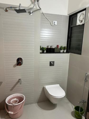 a small bathroom with a toilet and a window at Zen LuxStudio in Pune