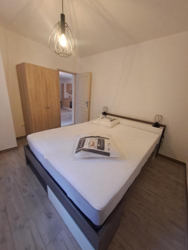 a large white bed in a room with a light at T2 Concoules - Panorama, Randonnées, Etapes motards in Concoules