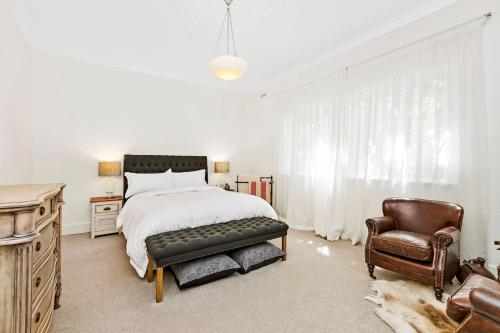 a bedroom with a bed and a leather chair at Stylish Apartment, Malvern East in Melbourne