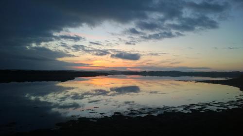 a reflection of the sky in the water at sunset at Carrabaun House in Westport