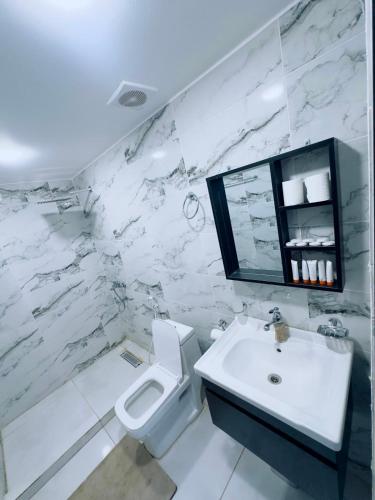 a white bathroom with a sink and a toilet at Rum Red Sand Luxury Camp & Jeep Tours in Wadi Rum