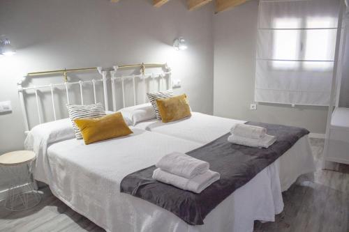 a bedroom with a large white bed with towels on it at Casa Rural El Morral in La Mata de los Olmos