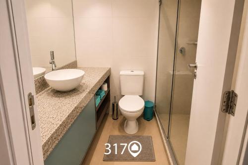 a bathroom with a toilet and a sink and a shower at Studio com Garagem e Acessibilidade | Granja Viana in Taboão da Serra