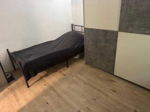 a bed with a black sheet in a room at BaumTraum in Fürthen
