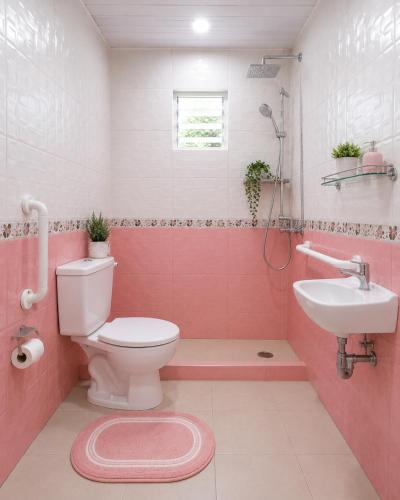a pink bathroom with a toilet and a sink at Cascata- Pousada Encanto Do Mar in Santa Irene
