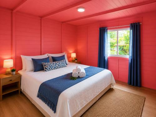 a bedroom with a large bed with red walls at Cascata- Pousada Encanto Do Mar in Santa Irene