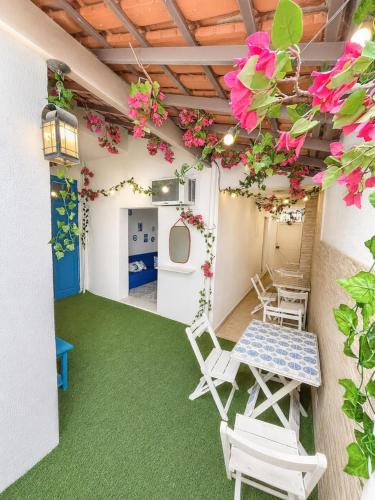 a room with chairs and a table and flowers at Casa Mykonos Rio in Rio de Janeiro