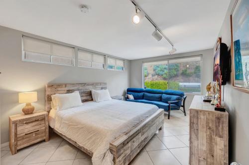 a bedroom with a large bed and a blue chair at OCEAN FRONT - STUNNING VIEWS- VACATION PARADISE!! in Dana Point