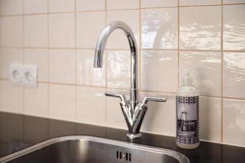 a kitchen sink with a bottle of soap next to it at Kortbie Zee in Biggekerke