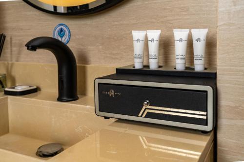 a kitchen sink with a faucet and three cups at فندق ايفر in Riyadh