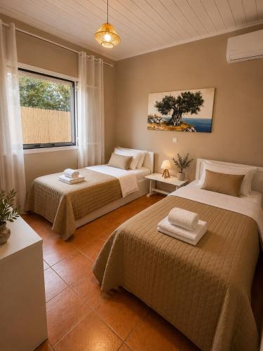 a bedroom with two beds and a window at Porto Vigla in Tranakatika