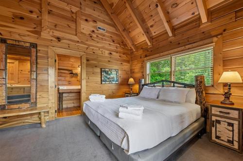 a bedroom with a bed in a log cabin at The Honeymoon Sweet #63 by Venture Smoky Mountains in Sevierville