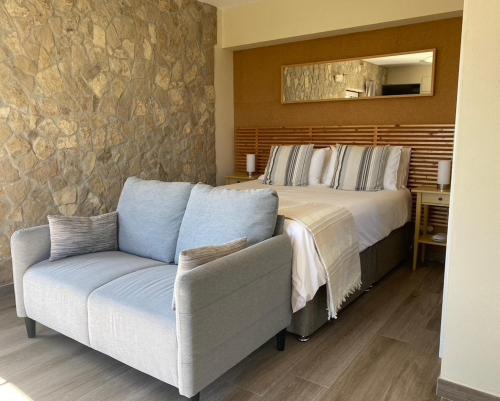 a bedroom with a bed and a couch at The Fig Boutique Suites in Salir de Porto