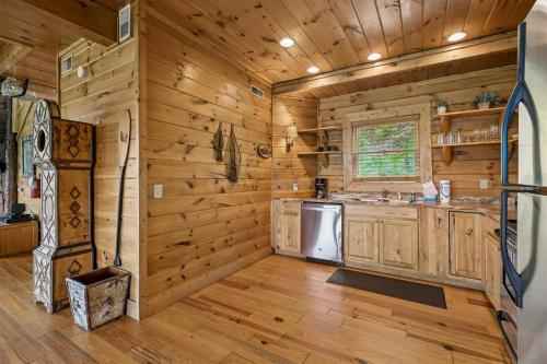 a kitchen with wooden walls and wooden floors at The Honeymoon Sweet #63 by Venture Smoky Mountains in Sevierville