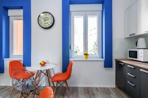 a kitchen with blue walls and a table and chairs at Sky Hostel in Zadar
