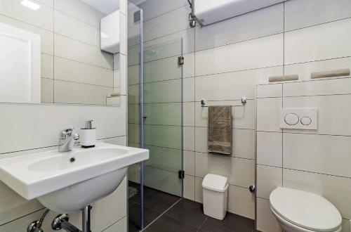 a white bathroom with a sink and a toilet at Sky Hostel in Zadar