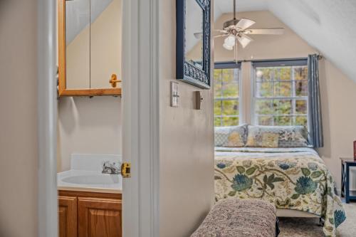 a bedroom with a bed and a sink and a mirror at Trails End River Retreat - Riverside in Berkeley Springs