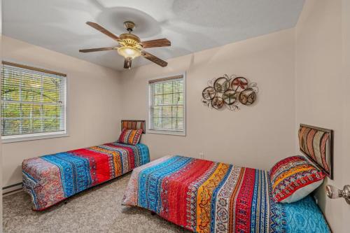 a bedroom with two beds and a ceiling fan at Trails End River Retreat - Riverside in Berkeley Springs