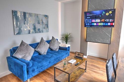 a living room with a blue couch and a glass table at Modern Family & Contractor Home - Free Parking - Garden - Sleeps 6 - Fast WiFi - in Bristol