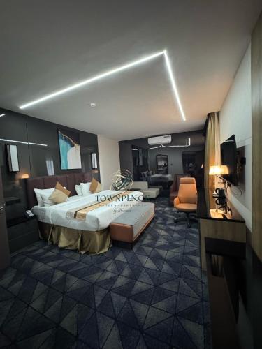 a hotel room with a large bed and a living room at Townplace Hotel & Apartments in Port Harcourt
