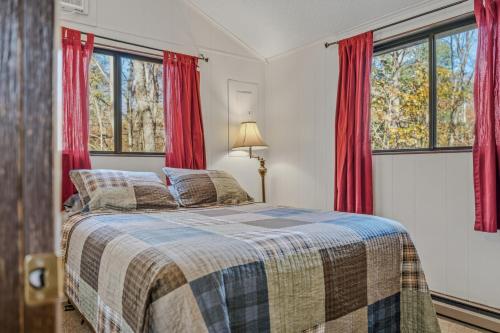 a bedroom with a bed with red curtains at Woods Song -- Hot Tub - Pet Friendly - Wifi - King Bed - Woods Resort - Golf Nearby - Pool Pass - Spa - Grill - Fireplace in Hedgesville