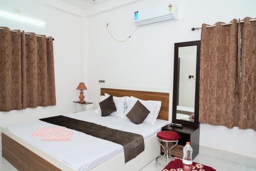 a bedroom with a bed and a mirror at Diya Homestay in Rāmpur Hāt