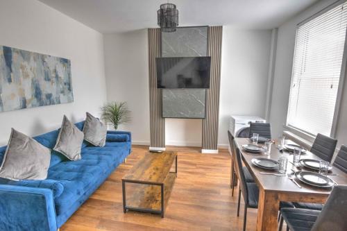 a living room with a blue couch and a table at Modern Family & Contractor Home - Free Parking - Garden - Sleeps 6 - Fast WiFi - in Bristol