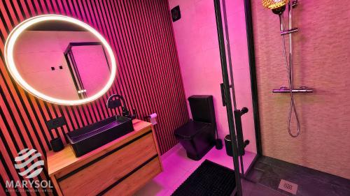 a pink bathroom with a sink and a mirror at Propiedad San Salvador in Mogán