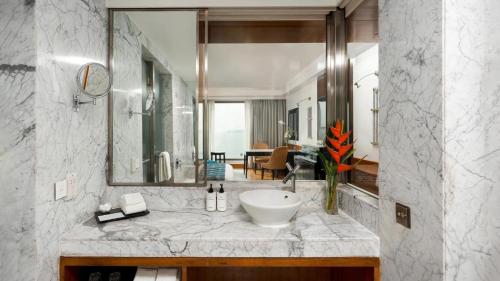 a bathroom with a sink and a large mirror at Hotel DSR Krone New Delhi in New Delhi