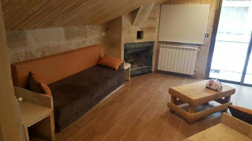 a room with a bed and a table and a fireplace at Villetta di Faraya in Fārayyā