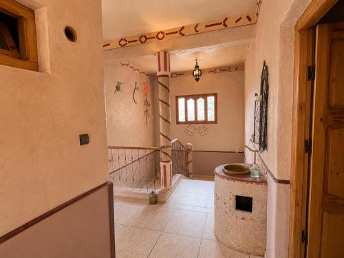 a hallway of a home with a table and a window at Auberge Restaurant Zahra in Boumalne Dades