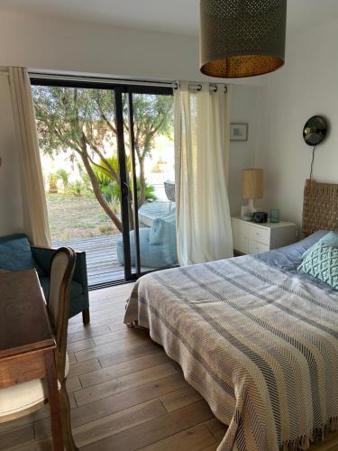 a bedroom with a bed and a sliding glass door at Les mimosas in Tosse