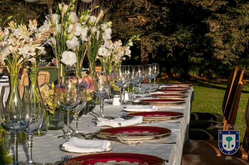 a long table with wine glasses and flowers on it at Hacienda los Lingues Chile Valle de Colchagua in Los Lingues