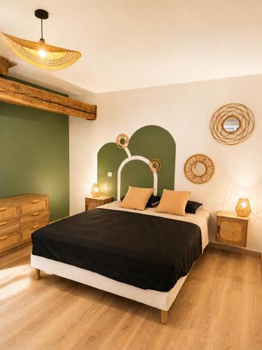 a bedroom with a large bed with a black blanket at Domaine de Beau Site in Peyrat-de-Bellac