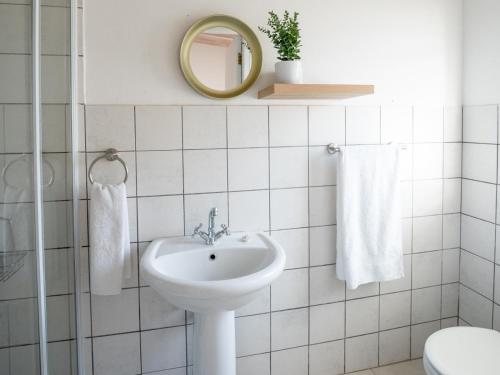 a white bathroom with a sink and a mirror at Ivory Pearl in Paternoster