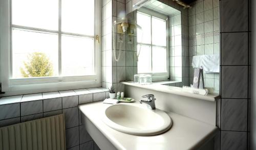Baño blanco con lavabo y espejo en Sorgerhof, en Frauental an der Lassnitz 