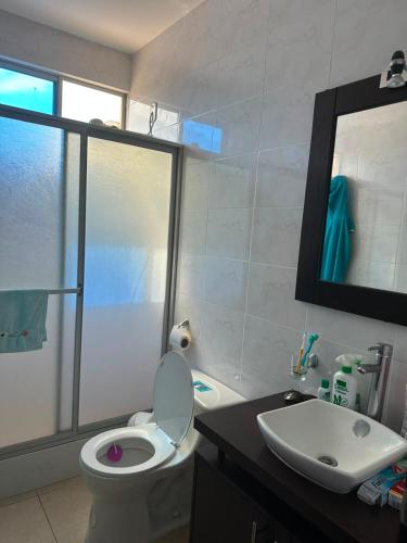 a bathroom with a toilet and a sink at Departamento impecable en Tonsupa, Conjunto Vacacional Salaverry VI in Tonsupa