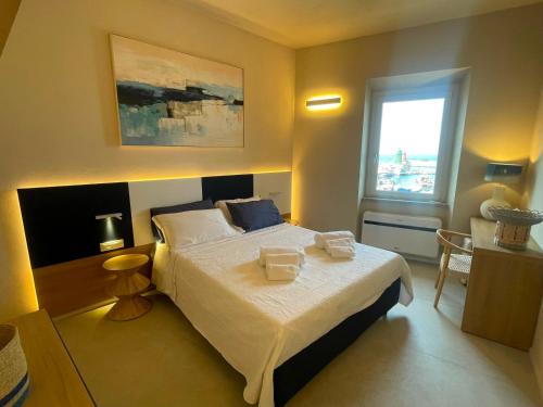 a bedroom with a bed with two towels on it at Calabianca in Giglio Porto