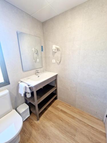 a bathroom with a sink and a toilet and a mirror at Olimar II in Cambrils