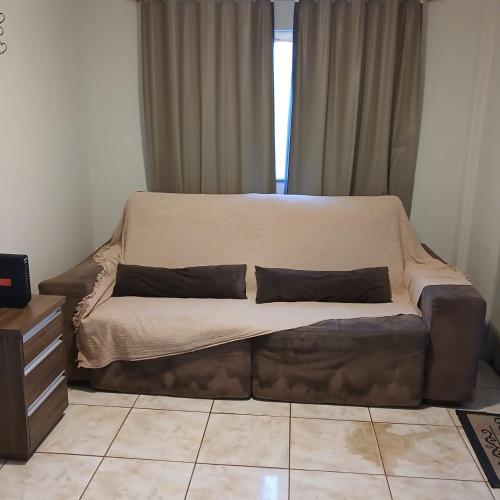 a couch with two pillows on it in a living room at Sobrado Morada do Sol! in Uberaba